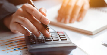 Closeup of female who are using their fingers to press the calculator for calculating bills in the office.finance report. Business office concept. Closeup of female who are using their fingers to press the calculator for calculating bills in the office.finance report. Business office concept.